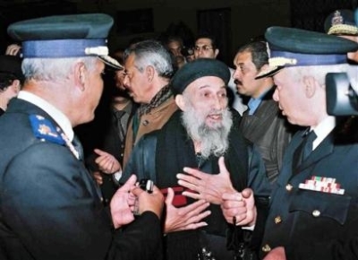 An Egyptian Coptic priest, center, negotiates with policemen outside the cathedral in the city's Abbasiya district, Cairo, Egypt, late Wednesday, Dec.8, 2004. More than a thousand Christians took over the Coptic Orthodox cathedral in Egypt's capital Wedne