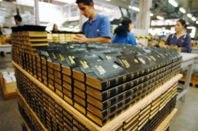 A worker arranges a pile of Bibles recently produced in a printing plant in Barueri, 30 miles north of Sao Paulo, Brazil. (AP Photo/Alexandre Meneghini)