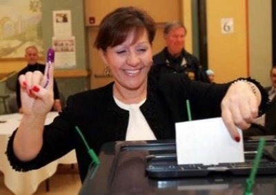 Iraqi Chaldean (Iraqi Catholic) expatriate Amira Vajoka shows her purple ink-stained finger as she casts her absentee ballot for the Iraqi election at a polling station in Farmington Hills, Michigan December 13, 2005. Vajoka is one of 240,000 Iraqi-Americ