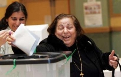 An Iraqi Chaldean (Iraqi Catholic) expatriate Sabraya Dawood (R) smiles as she casts her ballot for the Iraqi election at a polling station in Farmington Hills, Michigan December 13, 2005. Dawood immigrated to the U.S. in 1992 and is one of 240,000 Iraqi-