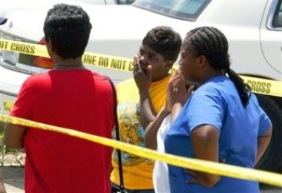 People gather in front of the Ministry of Jesus Christ church in Baton Rouge, La. Sunday afternoon May 21, 2006. A man opened fire Sunday morning at a church, fatally wounding four people before abducting his wife, whom he later shot to death at another l