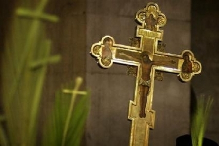 A cross is carried by Greek Orthodox pilgrims during a Palm Sunday mass in the Church of the Holy Sepulchre, traditionally believed to be the site of the crucifixion and burial of Jesus Christ, in Jerusalem 's Old City, Sunday, April 16, 2006.