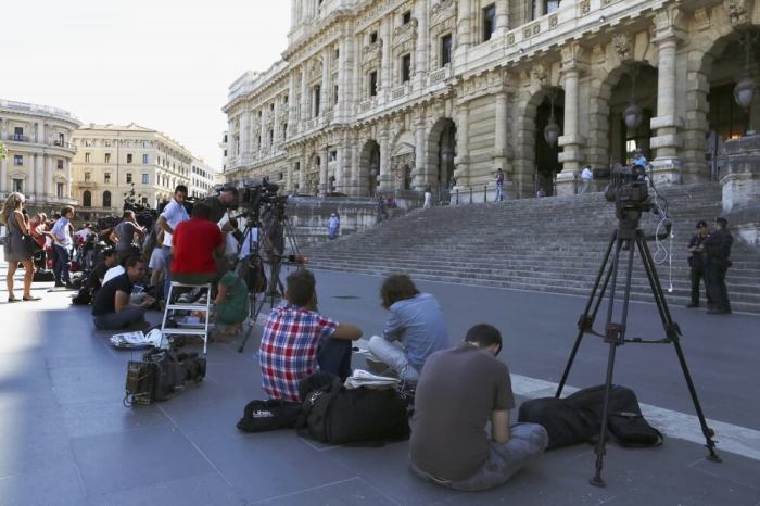 Reporters wait in front of Italy's supreme court building in Rome July 30, 2013. Italy's supreme court began considering on Tuesday former prime minister Silvio Berlusconi's last appeal against a jail sentence and ban from public office for tax fraud in a case which could threaten the survival of a shaky coalition government.