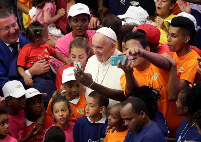 Pope Francis poses with refugees as he leads the weekly audience in Paul VI hall at the Vatican, Rome, Italy, August 3, 2016.