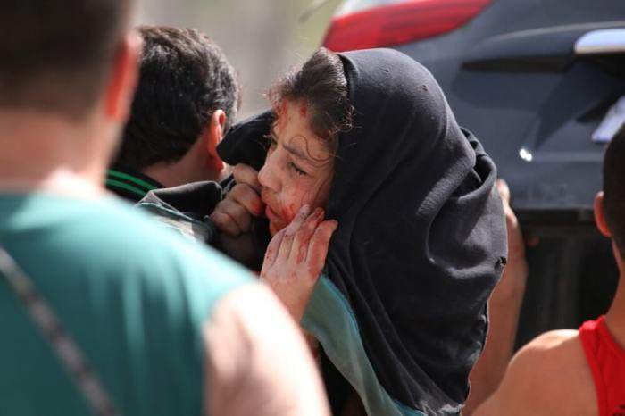 man carries an injured girl after airstrikes on the rebel held al-Qaterji neighbourhood of Aleppo, Syria, September 21, 2016.