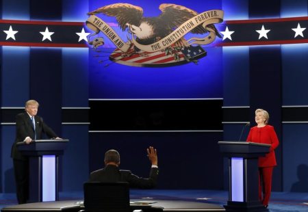 Moderator Lester Holt (C) raises his hand during the first presidential debate between Democratic U.S. presidential nominee Hillary Clinton and Republican U.S. presidential nominee Donald Trump at Hofstra University in Hempstead, New York, U.S., September 26, 2016.