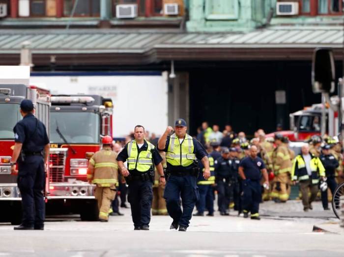 Hoboken police officers look over the scene of a train crash where a New Jersey Transit train derailed and crashed through the station, injuring more than 100 people, in Hoboken, New Jersey, September 29, 2016.