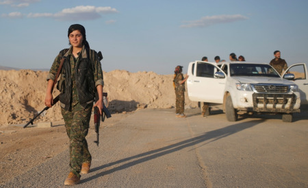 A female member of the Sinjar Resistance Units (YBS), a militia affiliated with the Kurdistan Workers' Party, carries a sniper and an AK-47 rifle in the village of Umm al-Dhiban, northern Iraq, April 29, 2016. They share little more than an enemy and struggle to communicate on the battlefield, but together two relatively obscure groups have opened up a new front against Islamic State militants in a remote corner of Iraq.