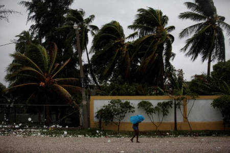 A woman protects herself from rain with an umbrella ahead of Hurricane Matthew in Les Cayes, Haiti, October 3, 2016.