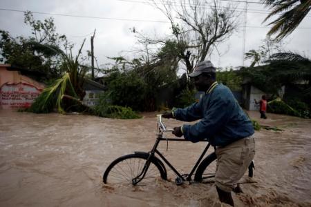 A man pushes a bicycle in a flood zone after Hurricane Matthew passed through Les Cayes, Haiti, October 4, 2016.