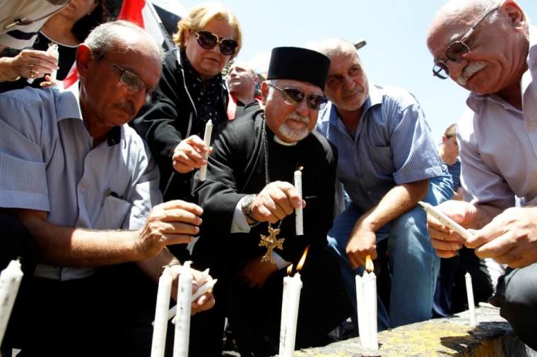 Christians light candles during Eid al-Fitr, the end of the fasting month of Ramadan, at the site of a suicide car bomb attack over the weekend at the shopping area of Karrada, in Baghdad, Iraq, July 8, 2016.