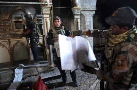 Iraqi special forces soldiers look at Christian religious books inside a church damaged by Islamic States fighters in Bartella, east of Mosul, Iraq October 21, 2016.