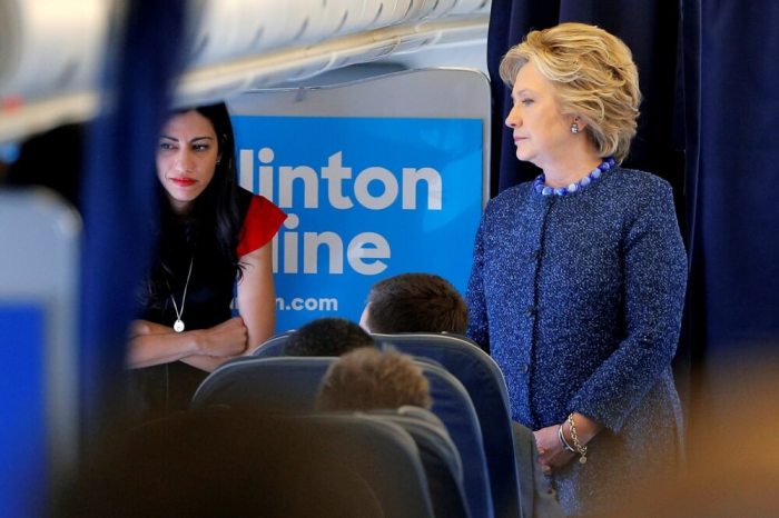 U.S. Democratic presidential nominee Hillary Clinton talks to staff members, including aide Huma Abedin (L), onboard her campaign plane in White Plains, New York, October 28, 2016.