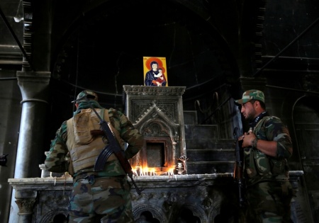 An Iraqi Christian soldier lights a candle during the first Sunday mass at the Grand Immaculate Church since it was recaptured from Islamic State in Qaraqosh, near Mosul in Iraq, October 30, 2016.