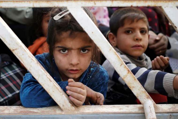 nternally displaced children sit in a pickup truck near Hassan Sham, east of Mosul, Iraq, October 25, 2016.