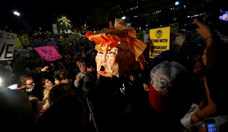 People hold a pinata while protesting the election of Republican Donald Trump as the president of the United States in downtown Los Angeles, California, November 9, 2016.