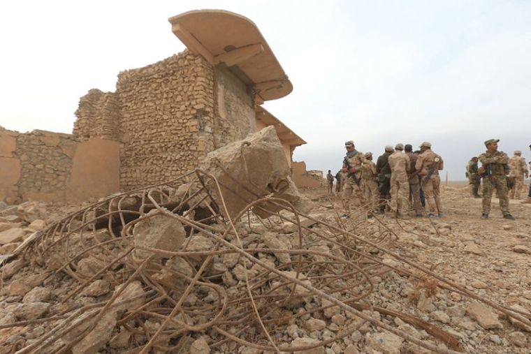 Members of Iraqi army gather at the remains of wall panels and colossal statues of winged bulls, destroyed by Islamic State militants in the Assyrian city of Nimrud eastern bank of the Tigris River.