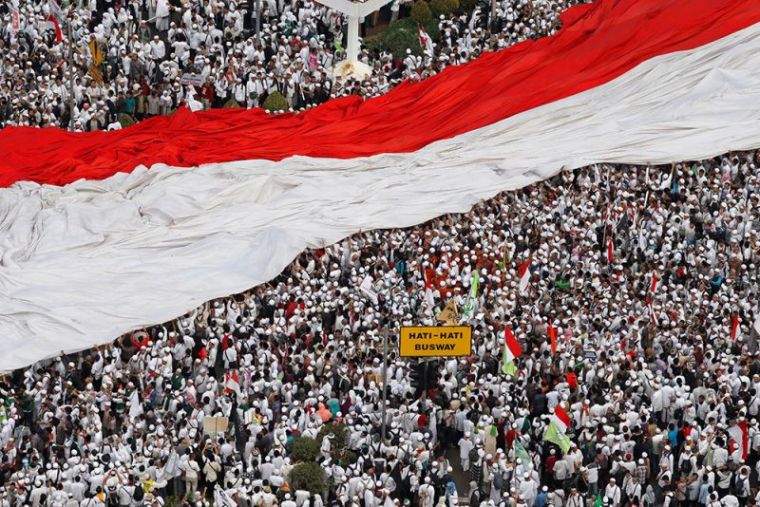 Members of hardline Muslim groups hold a big national flag as they attend a protest against Jakarta's incumbent governor Basuki Tjahaja Purnama, an ethnic Chinese Christian running in the upcoming election, in Jakarta, Indonesia.