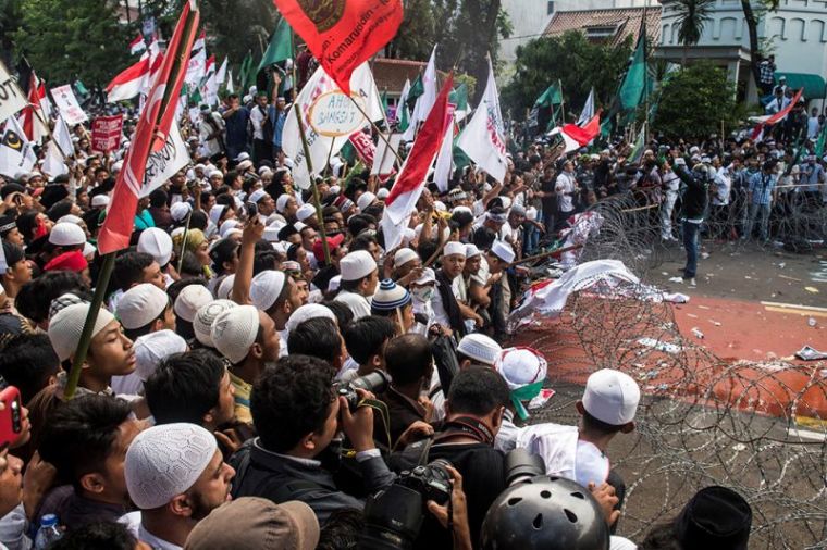 Muslim students broke the barb wire during a protest against Jakarta's incumbent governor Basuki Tjahaja Purnama, November 4, 2016.