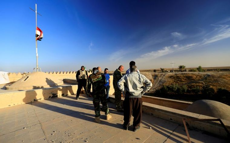 Fighters from the 'Kataeb Babylon,' a group of Christian fighters who fight alongside the Hashd Shabi, Shi'ite fighters, stand guard at the Mar Behnam monastery after the town was recaptured from the Islamic State, in Ali Rash, southeast of Mosul, Iraq, November 21, 2016.