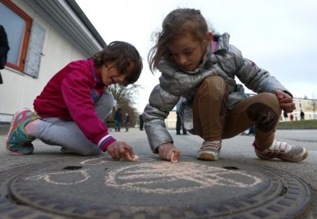 Children of migrants use chalk while playing in a refugee deportation registry centre in Manching near Ingolstadt, Germany, February 16, 2016.