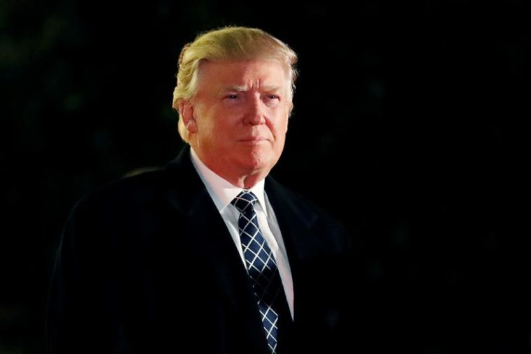 U.S. President-elect Donald Trump looks towards the media as he arrives at a costume party at the home of hedge fund billionaire and campaign donor Robert Mercer in Head of the Harbor, New York, December 3, 2016.