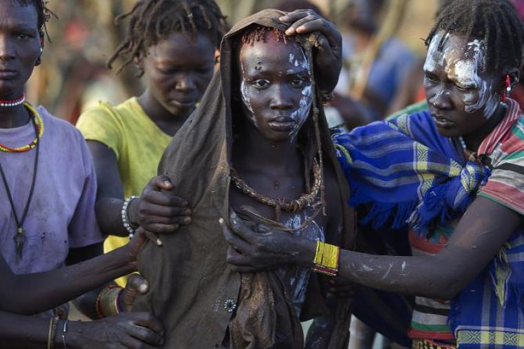 A Pokot girl walks to a place where she will rest after being undergoing genital mutilation in a tribal ritual in Baringo County, Kenya, Oct. 16, 2014.