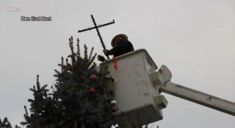 A city employee removes a cross from atop a Christmas tree in Knightstown, Indiana, on December 12, 2016.