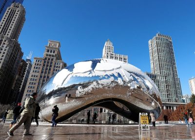 People walk by the snow-covered Cloud Gate sculpture (also known as The Bean) in Millennium Park in Chicago, Illinois, Dec. 13, 2016.