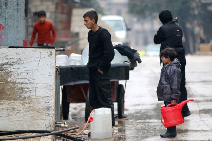 Civilians fill containers with water in a rebel-held besieged area of Aleppo, Syria, December 14, 2016.