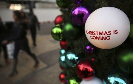 Shoppers walk past Christmas decorations in London, Britain, December 3, 2016.