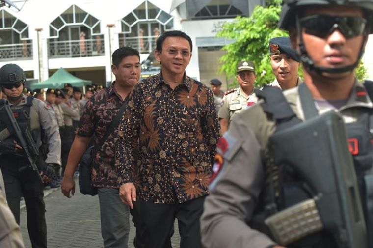 Jakarta's Christian governor Basuki Tjahaja Purnama alias Ahok (C) is escorted by anti-terror policemen as he leaves the North Jakarta court in Jakarta on December 20, 2016.