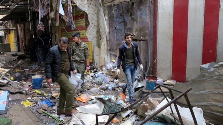 Iraqi security forces gather at the site of a bomb attack at a market in central Baghdad, Iraq, December 31, 2016.