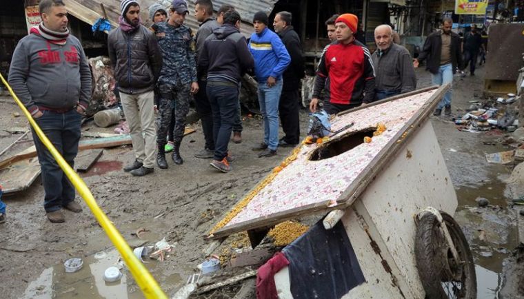 People gather at the site of a bomb attack at a market in central Baghdad, Iraq, December 31, 2016.