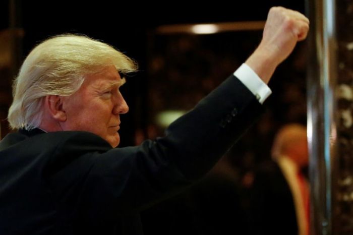 U.S.President-elect Donald Trump gestures to people in the lobby after speaking to the news media with television personality Steve Harvey and businessman Greg Calhoun after their meeting at Trump Tower in New York, U.S., January 13, 2017.