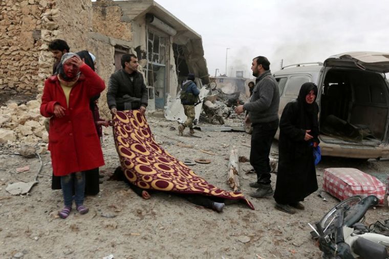 man covers a body while injured women react after a car bomb explosion in Jub al Barazi east of the northern Syrian town of al-Bab, Syria, January 15, 2017.