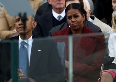 Outgoing U.S. first lady Michelle Obama listens with outgoing President Barack Obama (L) to incoming President Donald Trump speak during inauguration ceremonies at the U.S. Capitol in Washington, U.S., January 20, 2017.