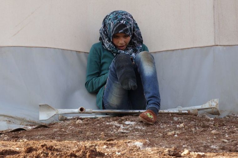 An internally displaced Syrian girl with an amputated leg checks her phone at the Bab Al-Salam refugee camp, near the Syrian-Turkish border, northern Aleppo province, Syria, January 19, 2017.