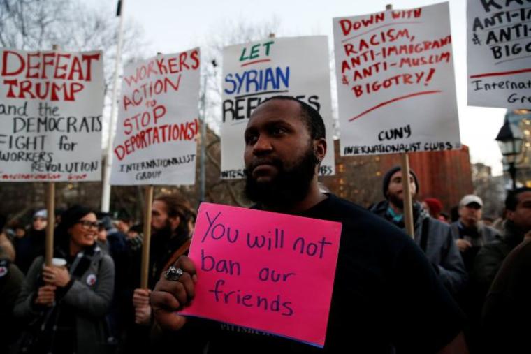 Isaiah Dupree holds a sign as demonstrators gather at Washington Square Park to protest against U.S. President Donald Trump in New York, January 25, 2017.