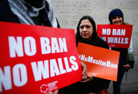 Demonstrators hold placards during a protest against U.S. President Donald Trump's executive order travel ban outside U.S. Embassy in Rome, Italy February 2, 2017.