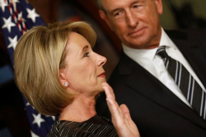 Betsy DeVos, joined by her husband Dick DeVos, is sworn in to be U.S. Education Secretary at the Eisenhower Executive Office Building at the White House in Washington, U.S. February 7, 2017.