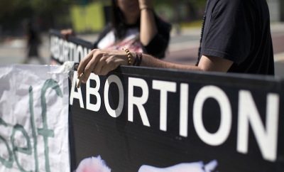 An activist holds a rosary while rallying against abortion in Los Angeles, California September 29, 2015.