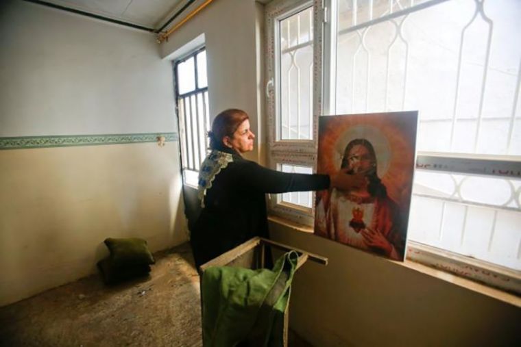 A Christian woman inspects a home in the town of Bartella east of Mosul, Iraq, after it was liberated from Islamic State militants, November 23, 2016.