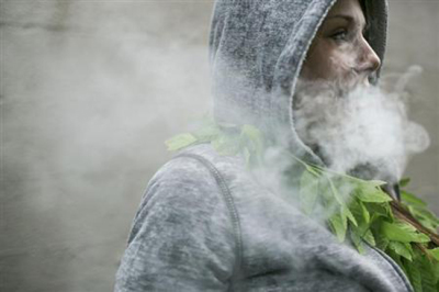 Mary Becker, 21, of Boise, Idaho exhales after taking a hit of hash oil at during 420Fest at the Luxe Nightclub in Seattle, Washington April 20, 2013.