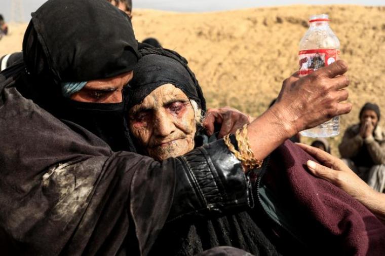 Displaced Iraqi women who just fled their home,rest in the desert as they wait to be transported while Iraqi forces battle with Islamic State militants in western Mosul, Iraq February 27, 2017.