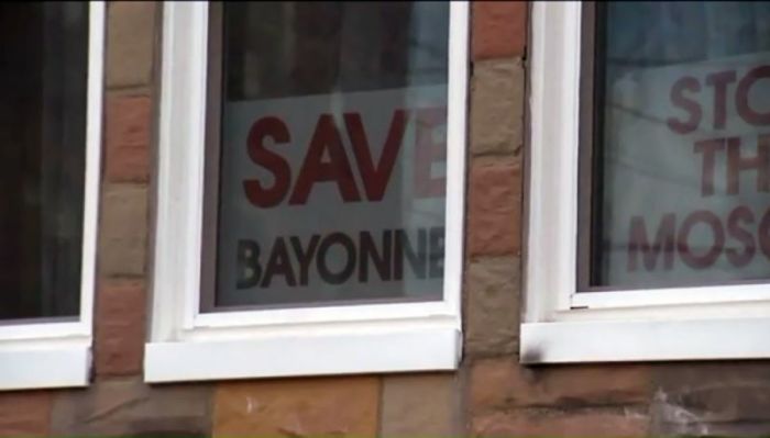 Signs opposing a plan to open a local mosque sit in the front window of Joseph and Patricia Basil's home in Bayonne, New Jersey, March 2017.