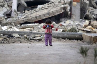 A girl plays near rubble of damaged buildings in al-Rai town, northern Aleppo countryside, Syria December 25, 2016.