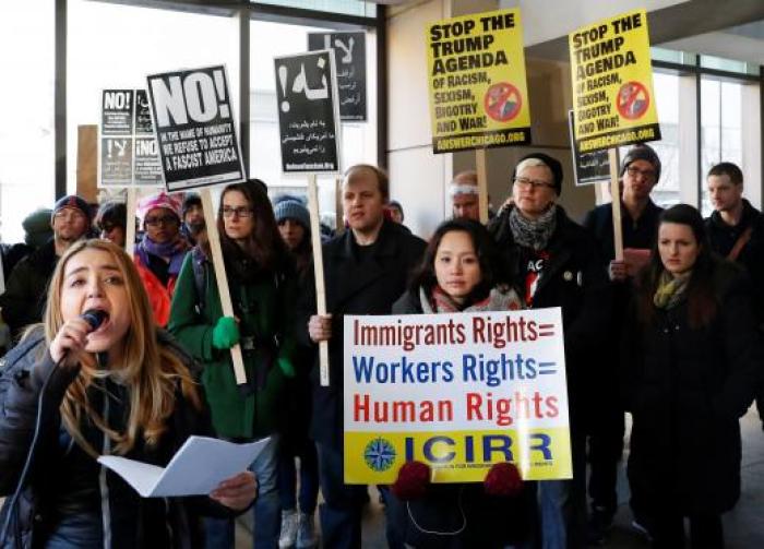 Demonstrators protest against President Donald Trump's revised travel ban outside the offices of the U.S. Immigration.