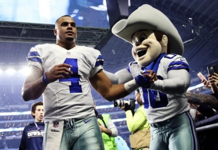 Dallas Cowboys quarterback Dak Prescott (4) celebrates with mascot Rowdy after the game against the Detroit Lions at AT&T Stadium, Dec. 26, 2016.