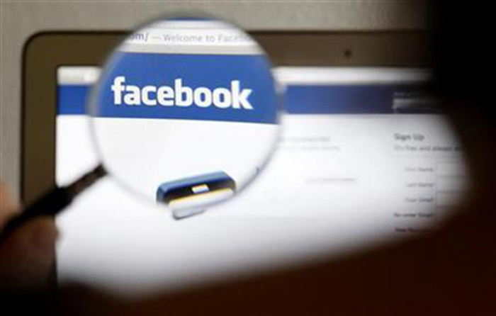 Credit : In this photo illustration, a Facebook logo on a computer screen is seen through a magnifying glass held by a woman in Bern May 19, 2012.